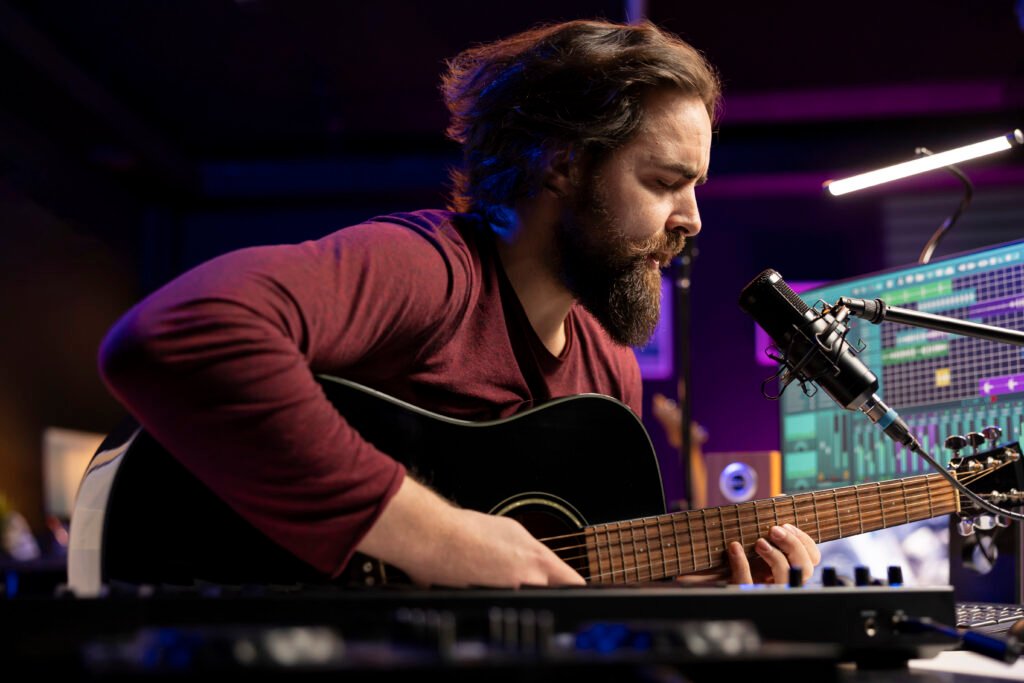 Songwriter composing a new song on acoustic guitar in home studio